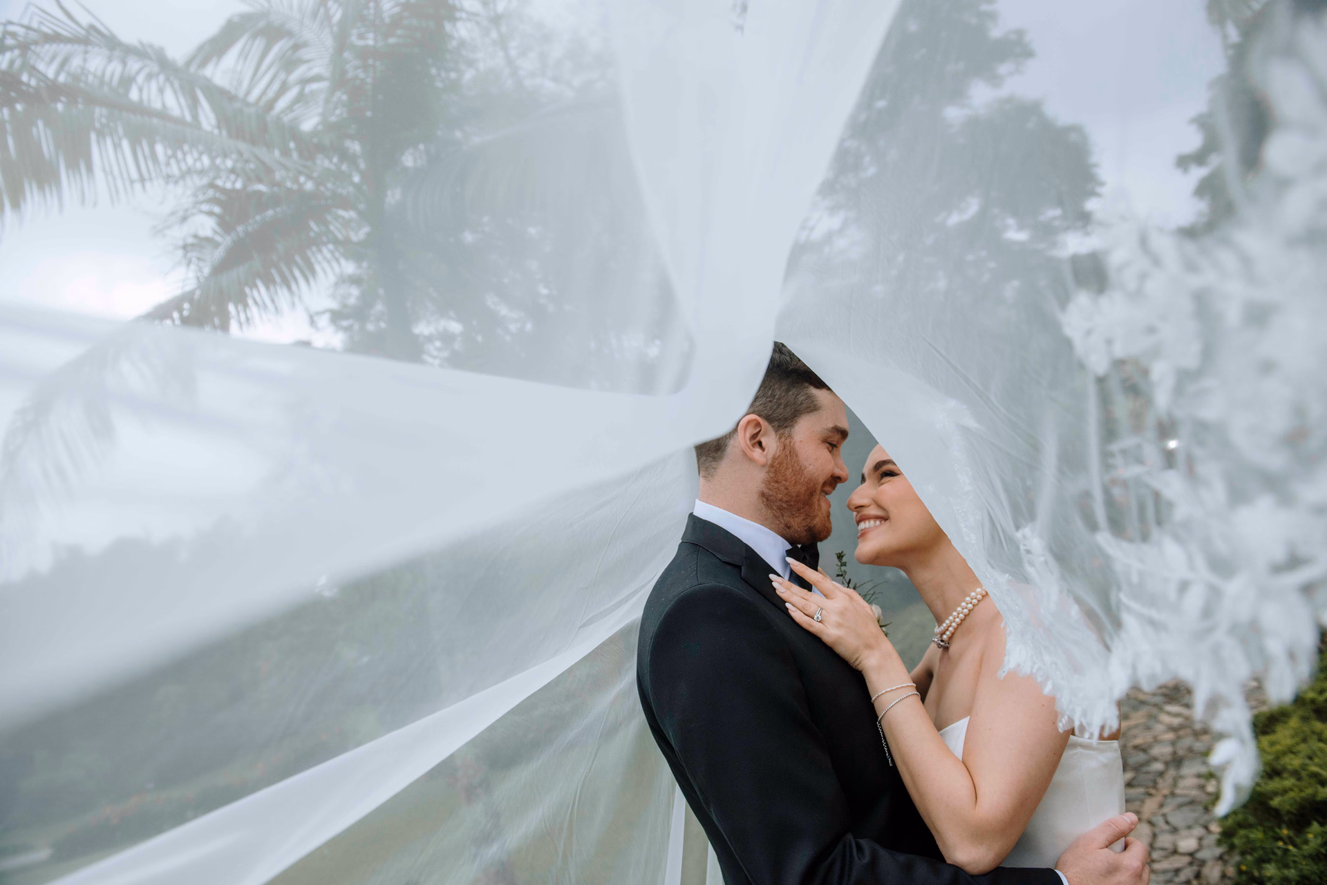 Bride beneath a softly lit veil in an editorial portrait