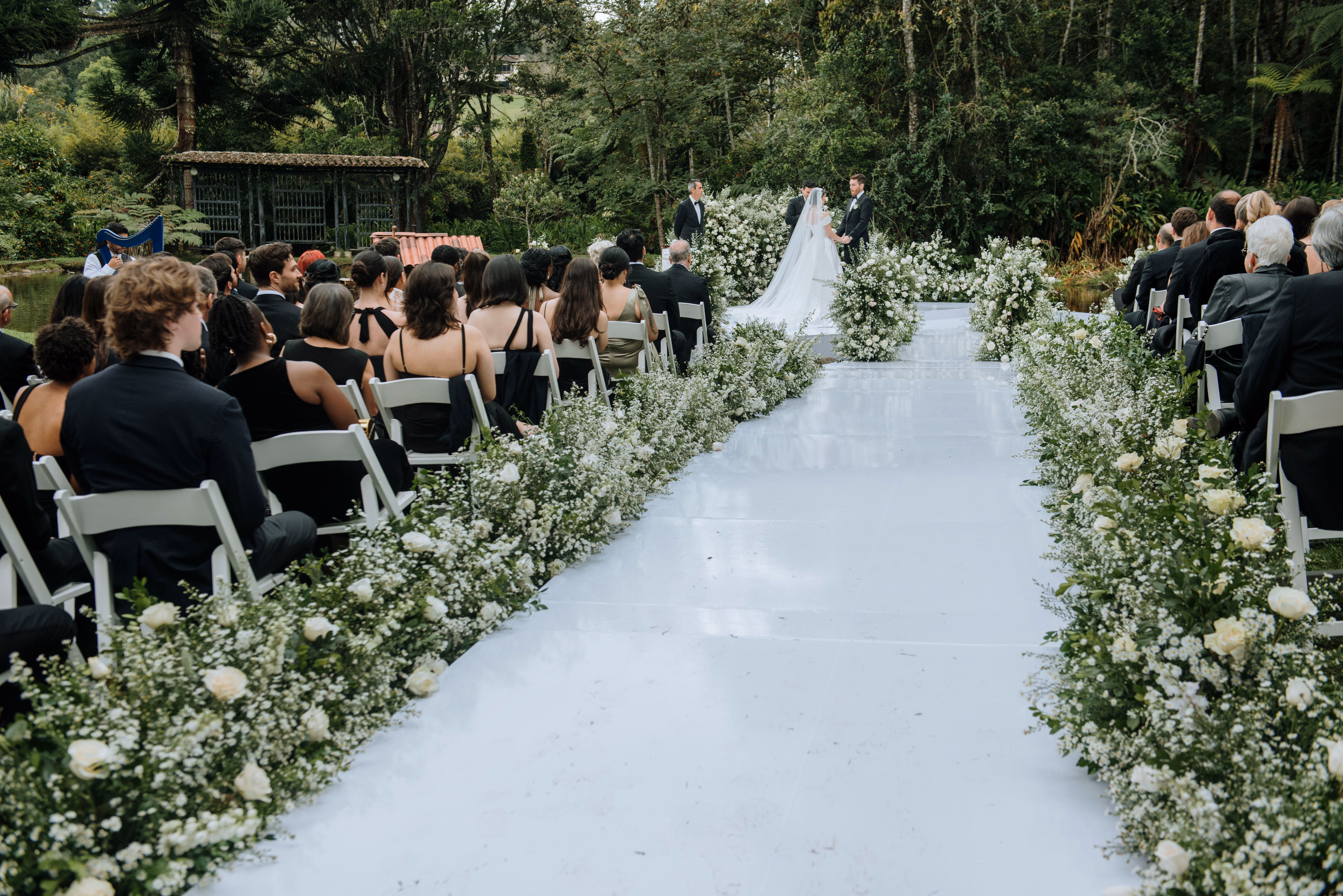 Outdoor wedding ceremony surrounded by white flowers