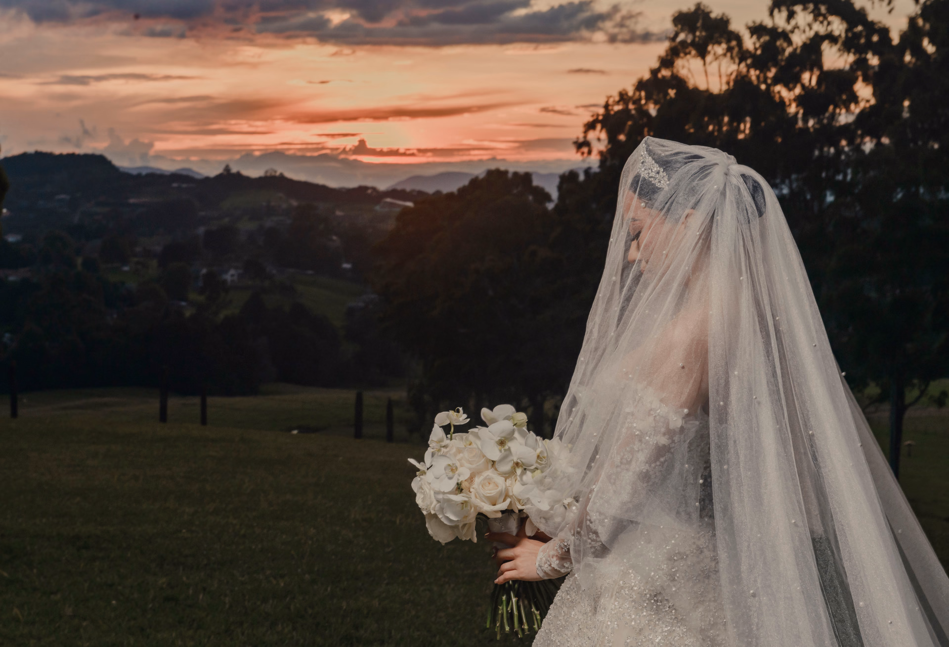 Bride beneath her veil at sunset in the mountains